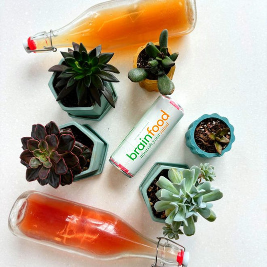 Three bottles of BrainFood sparkling water with a green label