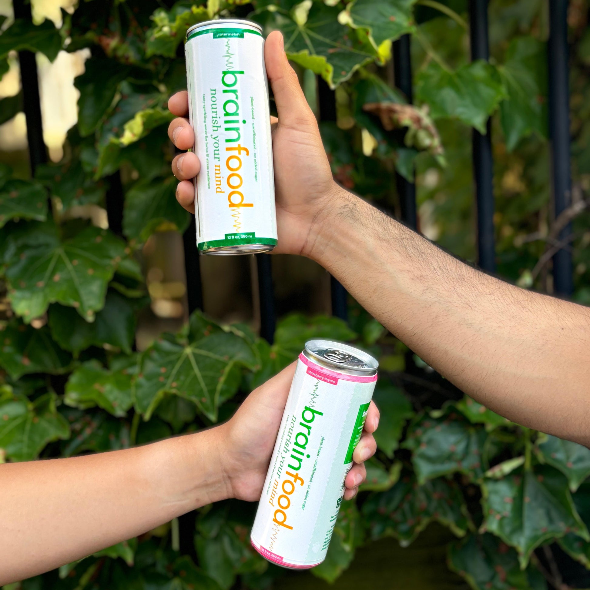 BrainFood Sparkling Water with Friends in from of Plants Outside
